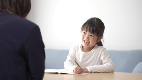young asian girl studying with mother