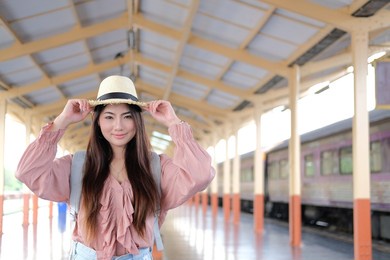 young asian woman  backpacker traveler with backpack at train station. journey trip travel concept