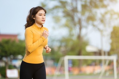 young woman running in the park in early morning
