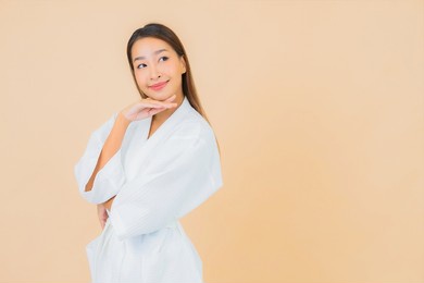 portrait beautiful young asian woman wear bathrobe with smile on color background