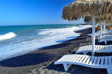 unique black volcanic pebble beach in kamari, santorini