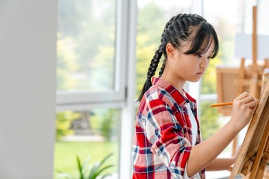asian girl drawing during class in art school indoors