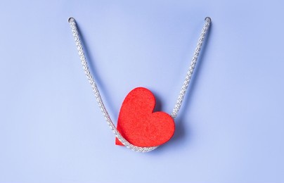 happy valentine's day concept with red heart on handle of shopping bag.