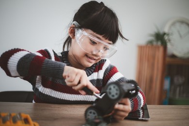 little girls having fun in a workshop coding robot car