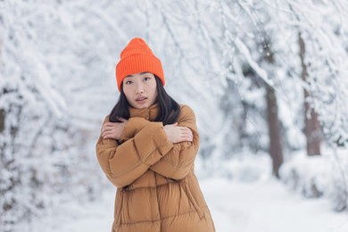 lonely asian woman in winter park, sad and depressed, tired and frozen dressed in warm clothes