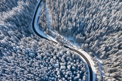 natural winter landscape from air. aerial view on the road and forest at the winter time. winter chill. forest and snow. the photo is in high resolution.
