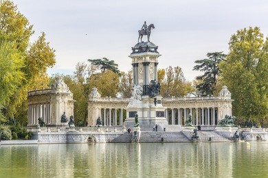 peaceful lake and monument to king alfonso xii (designer jose grases riera, 1922) in parque del buen retiro. buen retiro park - one of largest parks of madrid city. spain.
