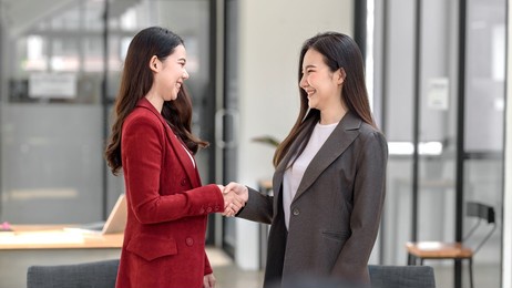 smiling young asian businesswoman shaking hands happy negotiations success.