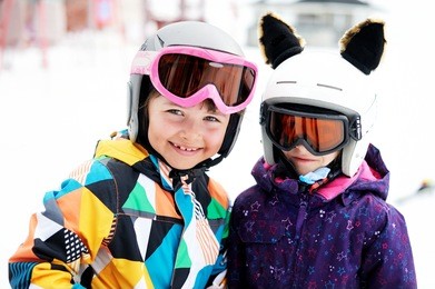 skiing, winter sports - two adorable kid girls in helmets