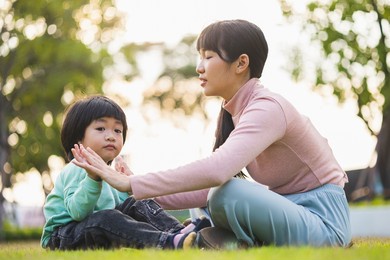 happy asian family mother and  kid spending time together at the park. son and mom have fun enjoy family time at weekend  with beautiful sun light. lifestyle moments. childhood and weekend concept