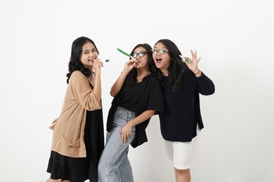 three asian people celebrating new year at home. the atmosphere is very glorious and they look happy.                              