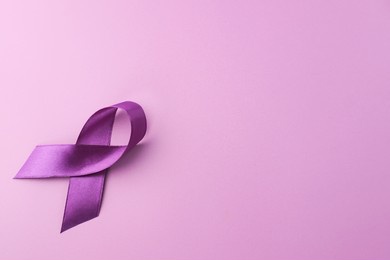 close up purple ribbon as symbol of world cancer day over purple color background, copy space.
