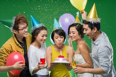 vietnamese young woman blowing candle on the cake