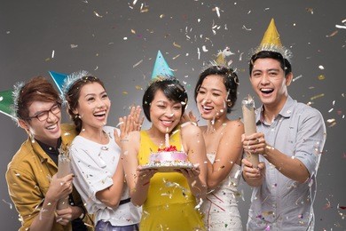 happy friends under falling confetti at the birthday party