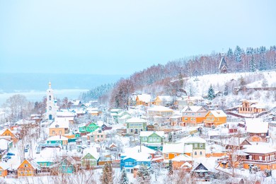 ancient russian town ples with old wooden colorful houses on the volga river in winter with snow. ivanovo region, russia.