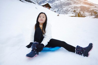grindelwald switzerland top of europe, asian teen wearing white coat.she is feel very happy on vacation in the mountains background.travel trip  snowy winter on mount grindelwald in switzerland, 