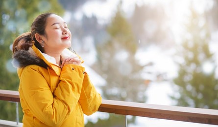 grindelwald switzerland top of europe, asian woman wearing yellow coat.she is feel very happy on vacation in the mountains background.travel trip  snowy winter on mount grindelwald in switzerland, 