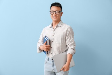 portrait of asian teacher with laptop on color background