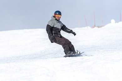 young man snowboarding on the slopes of a ski resort.