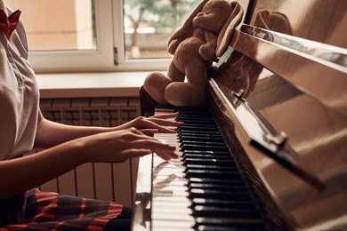 asian high school student sitting at the piano