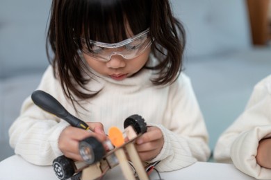 inventive kid constructing robot cars at home