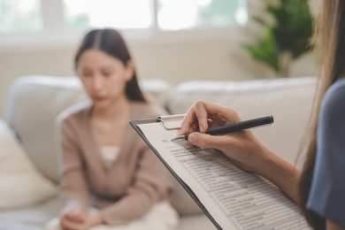 psychology, depression. sad, suffering asian young woman consulting with psychologist, psychiatrist while patient counseling mental with doctor woman taking notes at clinic. encouraging, therapy.