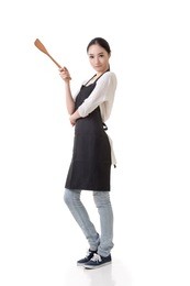young asian housewife hold a spatula in apron, full portrait isolated on white background.