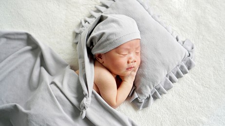 sleeping baby on pillow with blanket
