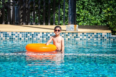 asian boy swim at the swimming pool in summer
