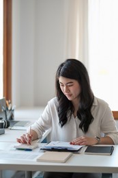 portrait asian business woman working with calculator hand pointing graph discussion and analysis data charts and graphs.business finances and accounting concept