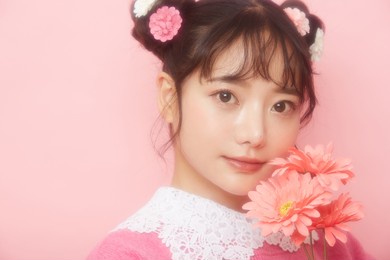 girly portrait of young asian woman on pink background shot by soft focused