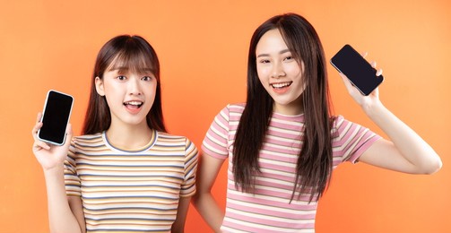 young asian woman posing orange background