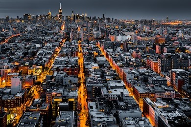 aerial view of new york city at night with illuminated avenues converging towards midtown.