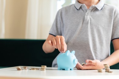 kid teen boy saving money putting coins in a piggy bank. learning financial responsibility and projecting savings. the concept of saving money, finance, business and investment. lessons in mindfulness