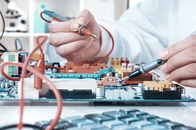 electronics repair service, hands of female tech fixes an electronic circuit