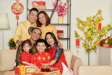hugging grandparents, parents and children in traditional ao dai dresses hugging and smiling at camera