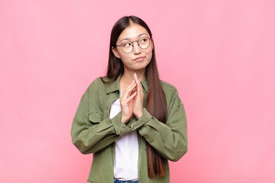 asian young woman scheming and conspiring, thinking devious tricks and cheats, cunning and betraying