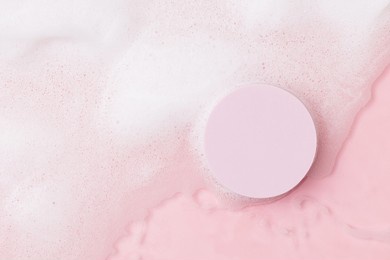 top view of pink transparent clear calm water surface. texture with splashes, foam and bubbles with pink podium. trendy abstract spring summer nature background for product. flat lay cosmetic mockup