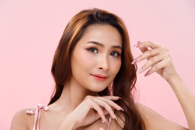 half body portrait of 20s fashion asian woman tan skin has beautiful brown hair style from stylish. girl wears sweet dress, express feeling happy smile and fashion poses over pink background isolated