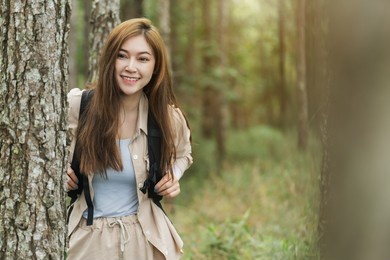 young happy woman carrying a backpack travel in the forest