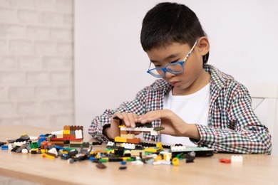 happy boy has fun playing lego