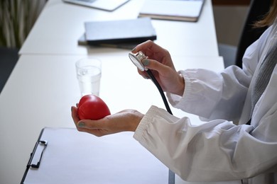 cropped shot female doctor  holding red heart shape and stethoscope. healthcare and medical concept.