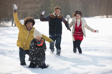 happy friends enjoying snowball fight