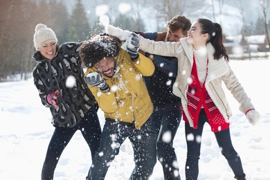 playful friends enjoying snowball fight