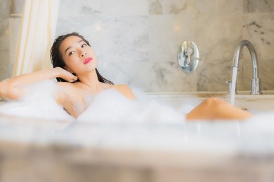 portrait beautiful young asian woman relax take a bath in bathtub in bathroom interior