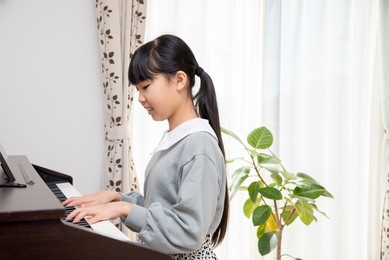 elementary school girl practicing the piano