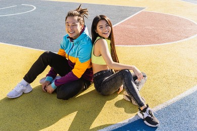 multicultural group of young friends bonding outdoors and having fun - stylish cool teens gathering at urban skate park, asian couple portrait