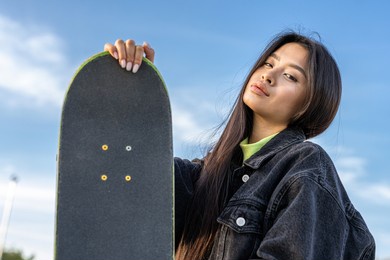 stylish cool teen female skateboarder at skate park, asian girl portrait