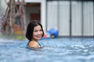 happy asian woman in swimming pool take a break on summer vacation.