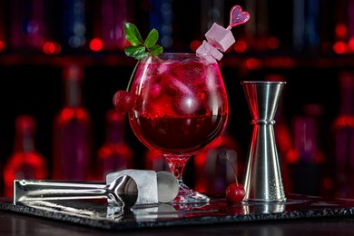 cherry daiquiri cocktail with ice on bar counter in a restaurant, pub. red drink with virgin cherry juice. fresh prepared alcoholic cooler beverage at a nightclub. showcases with bottles